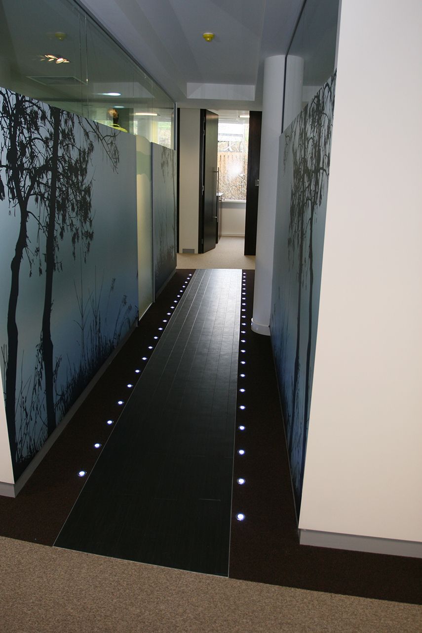 An office corridor with bespoke floor spot lighting.