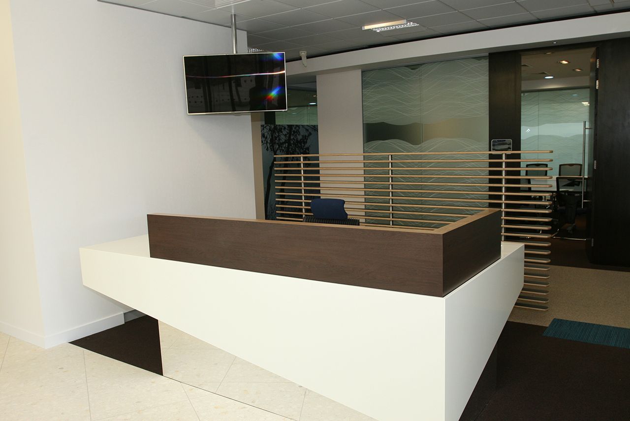 A small office reception with a front desk and a television suspended from the wall.