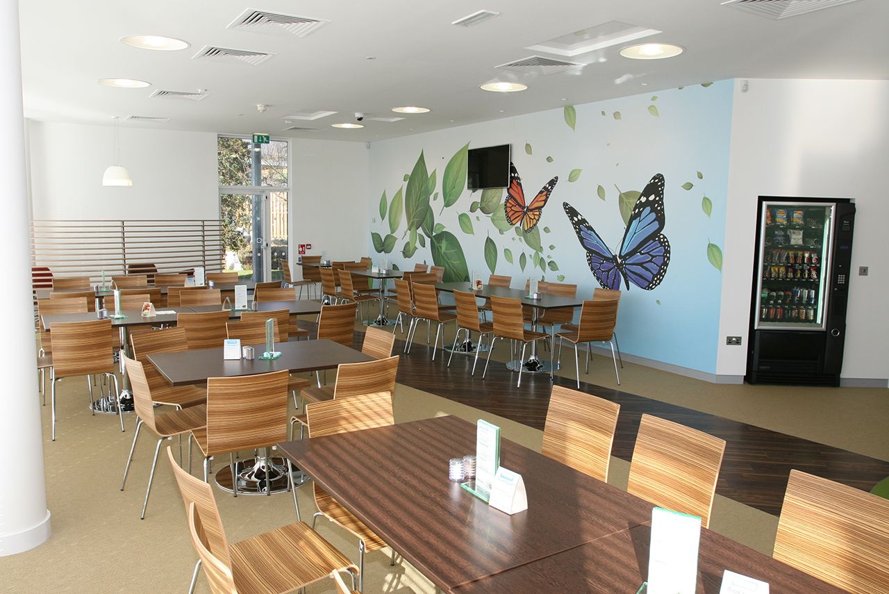 A cafe seating area with multiple tables and chairs.