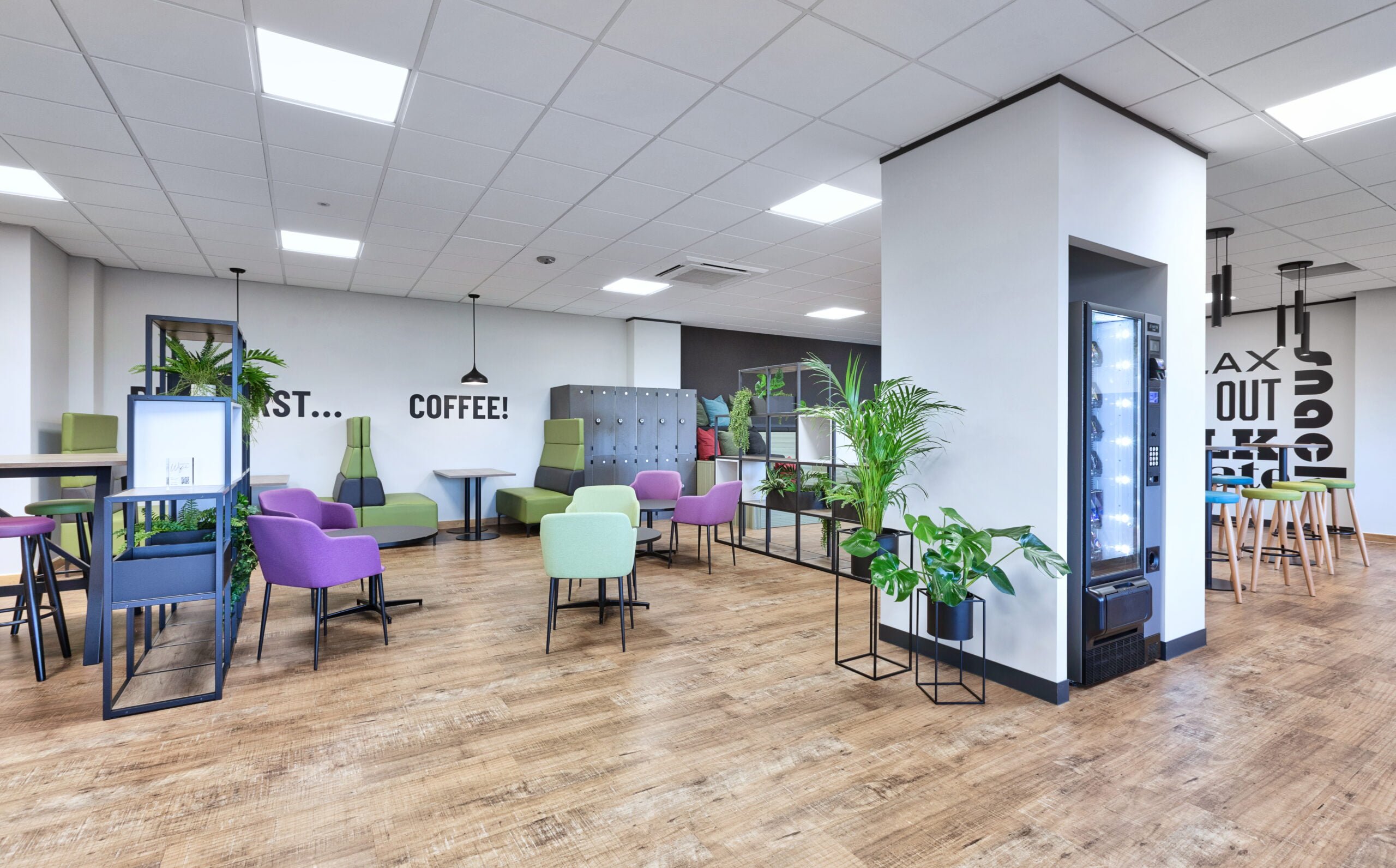 breakout space with biophilic elements, a vending machine, wooden flooring and colourful furniture